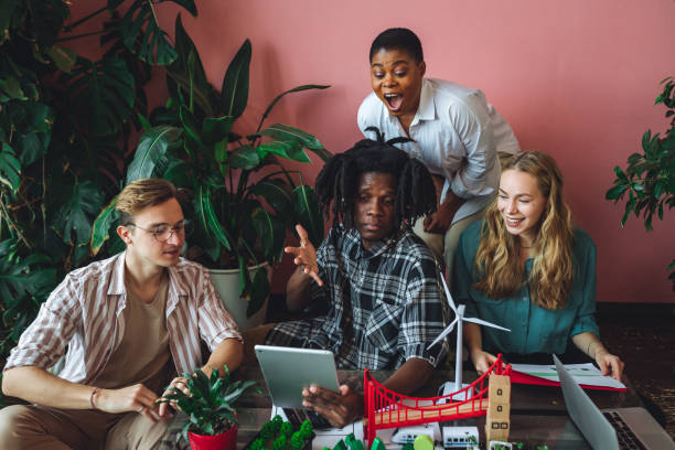 istock International diverse group of students working on modern urban architecture project with renewable green energy source, alternative electricity, waste recycling. Brainstorming ideas, business plan 1470869661
