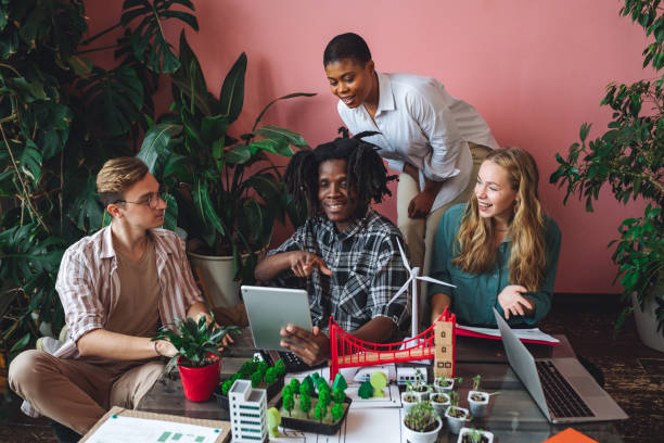 istock International diverse group of students working on modern urban architecture project with renewable green energy source, alternative electricity, waste recycling. Brainstorming ideas, business plan 1470869662