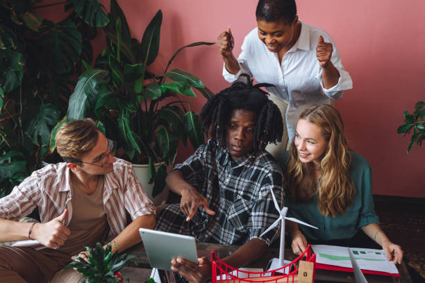 istock International diverse group of students working on modern urban architecture project with renewable green energy source, alternative electricity, waste recycling. Brainstorming ideas, business plan 1470869674