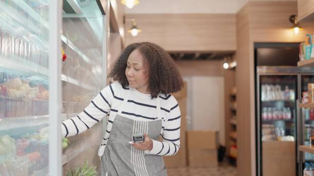 istock African American worker working in supermarket, use barcode scanners or handheld checking the number of products left on the shelf in shopping mall. Employee or head of fruit and vegetable department inspecting the quality of products sold on shelf. 1470871637
