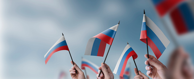 A group of people holding small flags of the Russia in their hands.