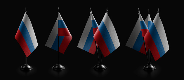 Small national flags of the Russia on a black background.