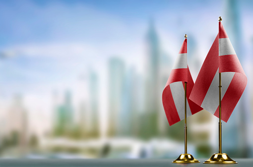 Small flags of the Austria on an abstract blurry background.