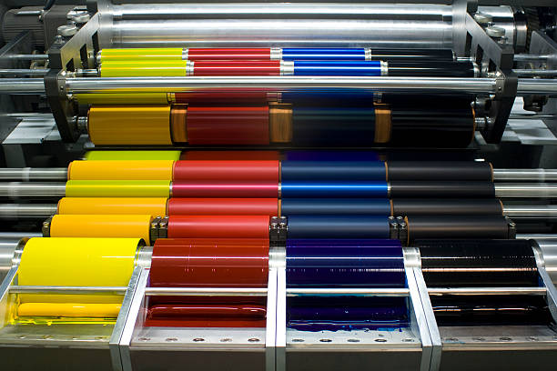 Offset Printing Press with CMYK Ink Rollers Ink rollers on an offset printer printing plate photos stock pictures, royalty-free photos & images