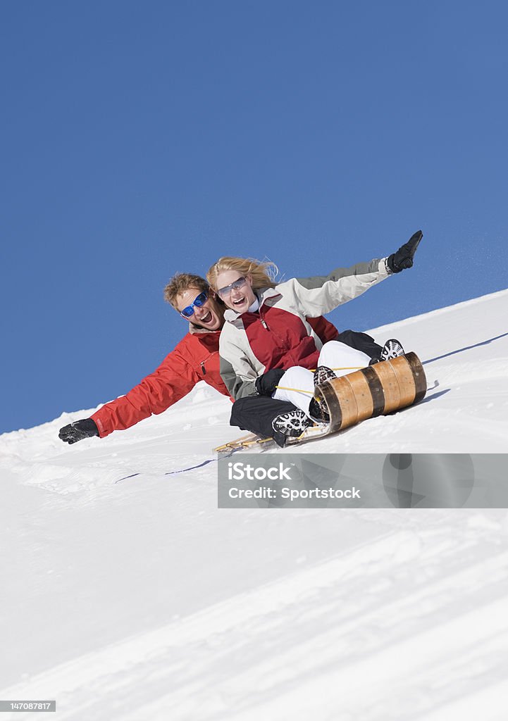 Couple Sledding In Colorado USA Young man and woman having fun sledding in Loveland, Colorado. Activity Stock Photo