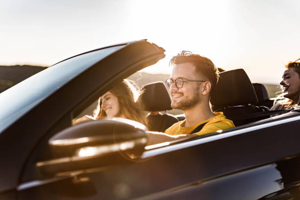 istock Young happy people going on a road trip by convertible car. 1470878581