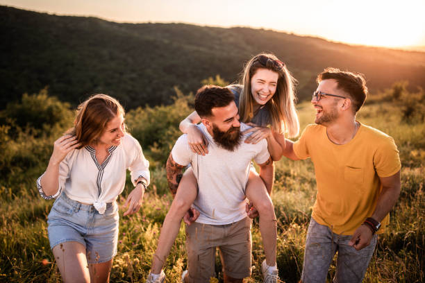 istock Cheerful friends talking while walking up the hill at sunset. 1470878714