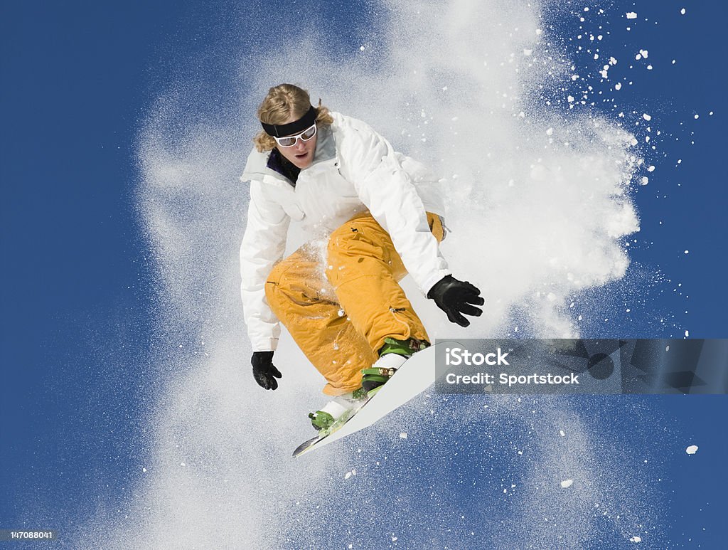 Snowboard Jumping In Colorado Young man high in air making extreme snowboard jump in powder snow against deep blue sky. Active Lifestyle Stock Photo