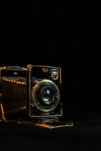 istock Antique fold photocamera on black background 1470882762