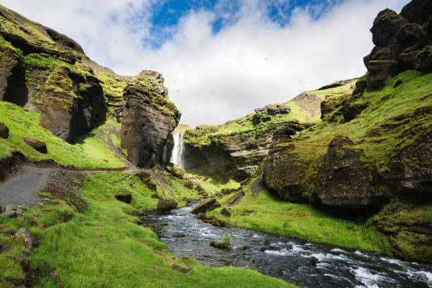 cascada de kvernufoss que fluye a través del valle verde en un día soleado en verano en islandia - waterfall river stream mountain fotografías e imágenes de stock