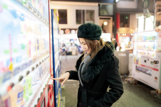 istock Woman tourist buying drinks from vending machine at night 1470883833
