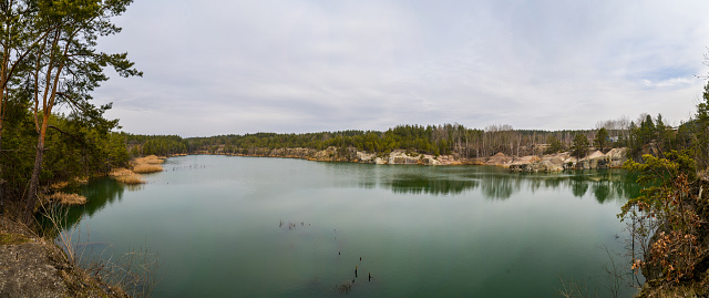 beautiful abandoned granite quarry with a large lake in a pine forest