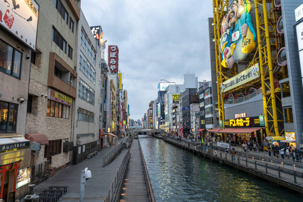Osaka, Japan - 02 February, 2023. A winter night shot on Dotonburi street shopping in Osaka, Japan. Crowded People walking around at the Dotonburi road. Dotonburi is the district is known as one of the main shopping and tourism areas in Osaka,Japan.