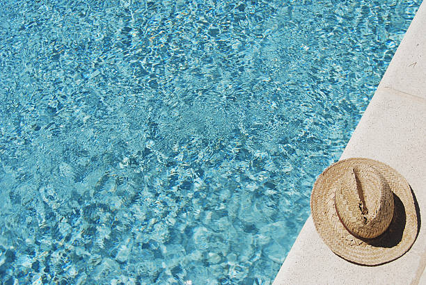 istock Straw Hat On The Side Of A Swimming Pool 147088906