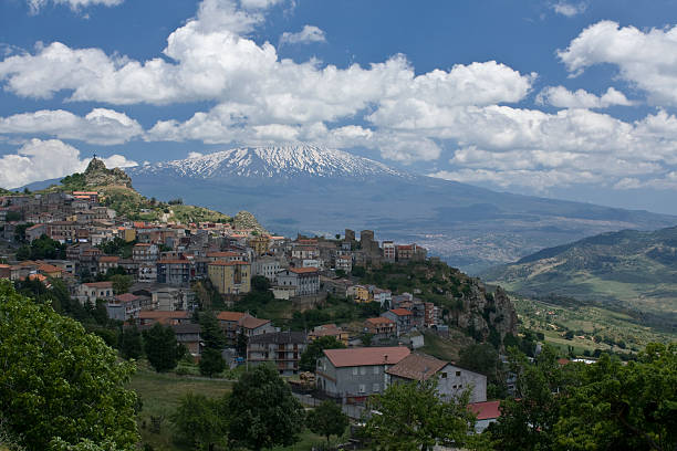Landscape view of some houses with Mount Etna in background stock photo