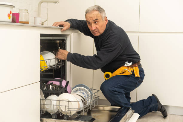 istock Repairman Examining Dishwasher With Toolbox In Kitchen 1470891456