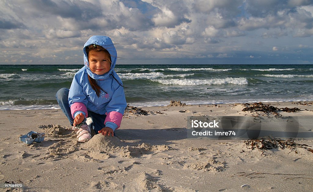 Littlegirl en la playa tiene en el viento - Foto de stock de Jugar libre de derechos