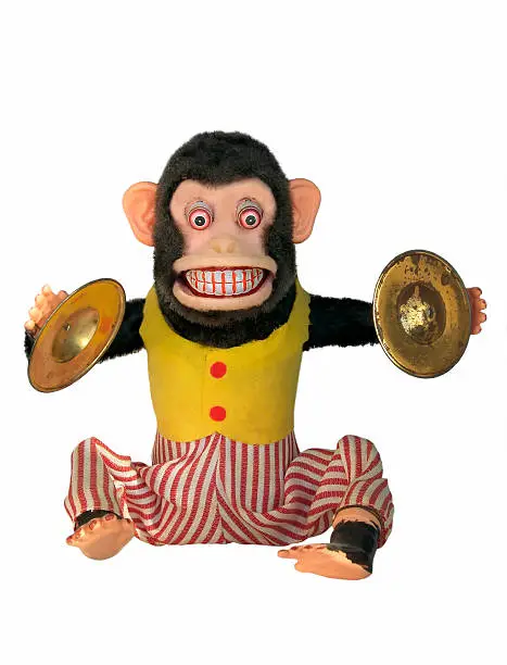 Vintage mechanical monkey toy with cymbals showing teeth, full body isolated on white background