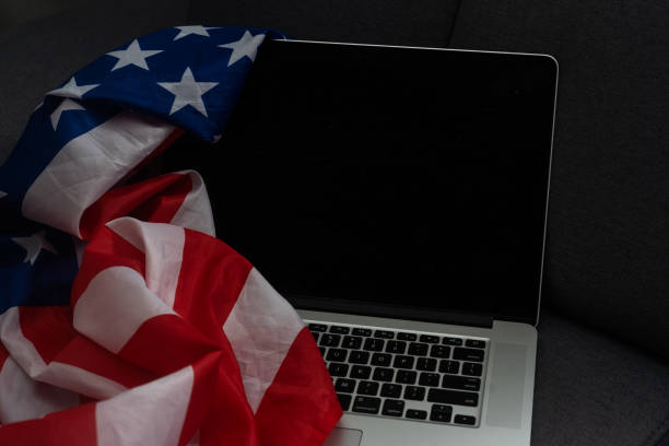 istock US flag and laptop on background with copy space. 1470894973