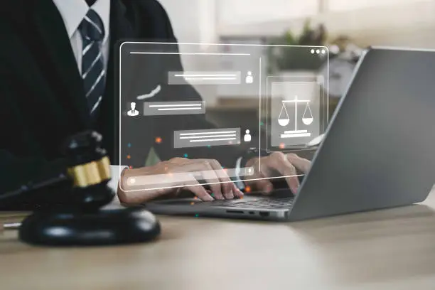 Photo of Hand of the businessman or  Lawyer with legal services icon on the laptop screen for Legal advice online in Labor law for a business company legal. concept of legal consultant and lawyer