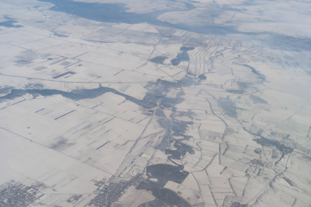 旅行と輸送のコンセプトで窓から雲の上を飛ぶ飛行機ジェットの航空写真の翼。冬の白い雪山。自然の風景の背景。 - mountain range earth sky airplane ストックフォトと画像