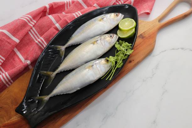 istock Uncooked Indian mackerel fish Rastrelliger kanagurta. also known as Bangda fish. Free copy space. Lemon wedge and coriander. top view fish background. online fish marketing. 1470898625
