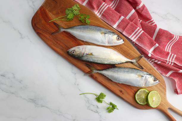 istock Uncooked Indian mackerel fish Rastrelliger kanagurta. also known as Bangda fish. Free copy space. Lemon wedge and coriander. top view fish background. online fish marketing. 1470898695