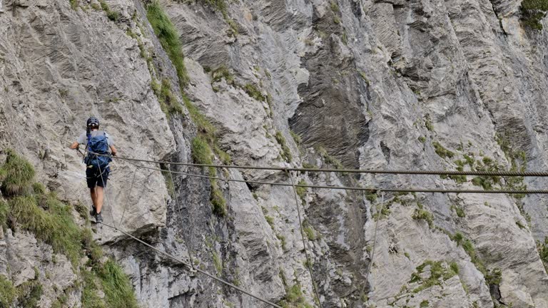 Man on Via Ferrata crossing monkey bridge