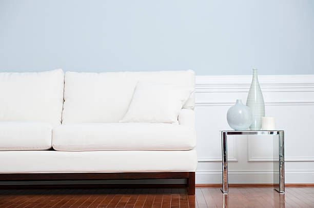 Biała kanapa i szkła Koniec tabeli ścianę niebieski przed – zdjęcie