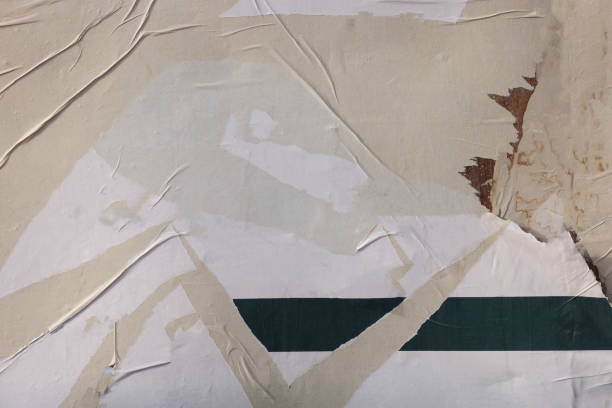 Pieces of torn paper peeling off wall used as billboard