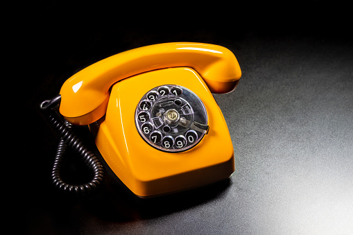 Vintage telephone on old table sepia photo