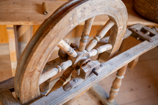 Very old wooden spinning wheel in a farm house