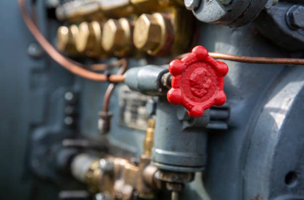 Red valves control the steam flow in a vintage locomotive, reflecting the engineering of historical railway systems.