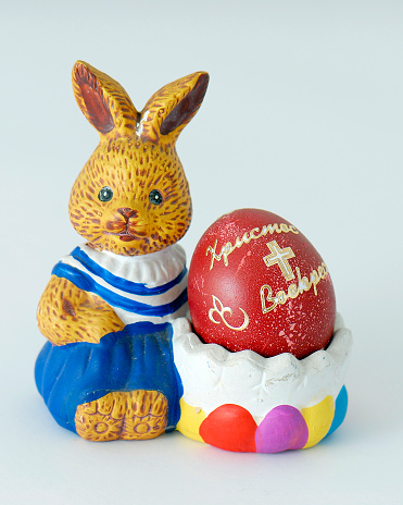 Orthodox red Easter egg with Cyrillic inscription and decorative Easter bunny on white background
