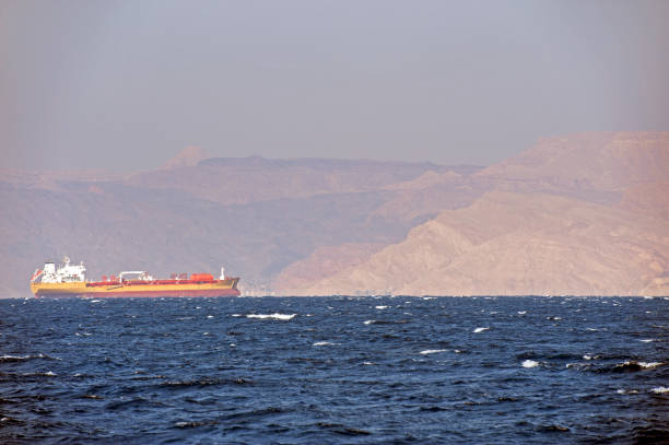 Freighter makes headway towards the Red Sea port of Aqaba, Jordan with Sinai Desert behind stock photo