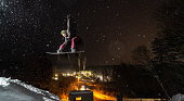 Snowboarder doing a jump at night