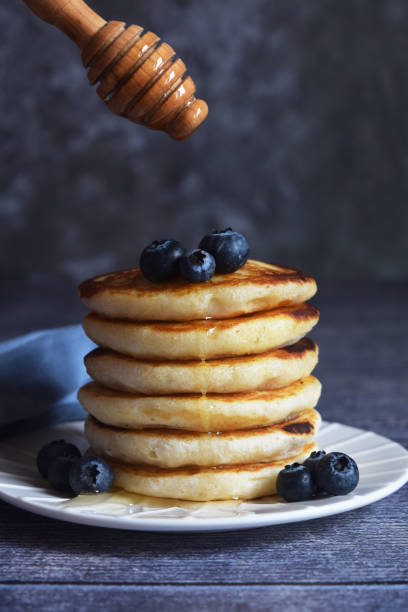 istock a stack of pancakes with blueberries and a spoon with honey 1470913444
