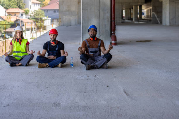 A Group of Multicultural Workers are Resting During a Work at Building Site and Doing Yoga Exercises.