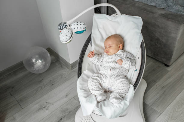 adorable bebé duerme en bebé mecedora en la habitación. concepto de recién nacido. - swing rocker fotografías e imágenes de stock