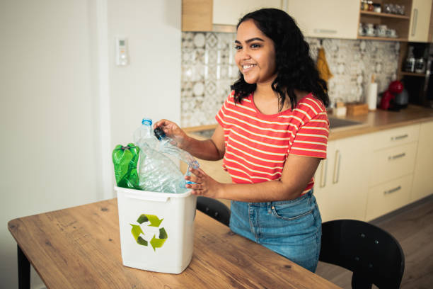 istock Happy young woman collecting plastic for recycling 1470921220