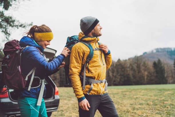istock Couple of hikers helping each other get ready before going on a hike 1470925072