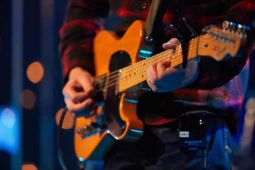 Cropped shot of a guitarist performing on stage