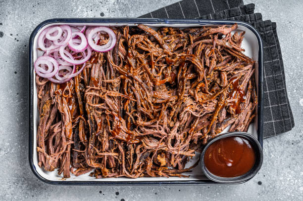 istock Pulled beef meat with hot chili sauce in baking dish. Gray background. Top view 1470926834