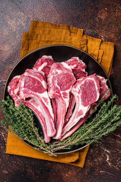 生のラムチョップ、リブに新鮮なマトンミートカツレツ。暗い背景。平面図 - rack of lamb chop raw meat ストックフォトと画像