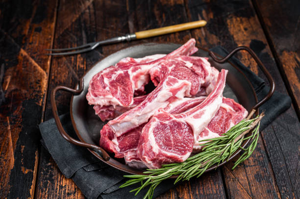 生のラムマトンチョップステーキ、肉屋のテーブルの上の新鮮な肉のカツレツ。黒い背景。平面図 - rack of lamb chop cutlet food ストックフォトと画像