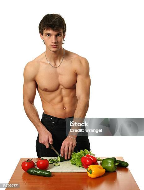 Joven Muscular Man Preparar Una Ensalada Foto de stock y más banco de imágenes de Adulto - Adulto, Adulto joven, Alimento