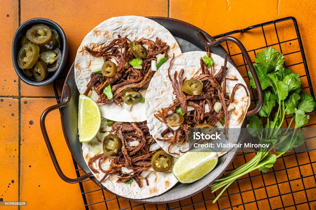 Spicy Beef Barbacoa Tacos with Cilantro and Onion. Orange background. Top view Spicy Beef Barbacoa Tacos with Cilantro and Onion. Orange background. Top view. Avocado Stock Photo