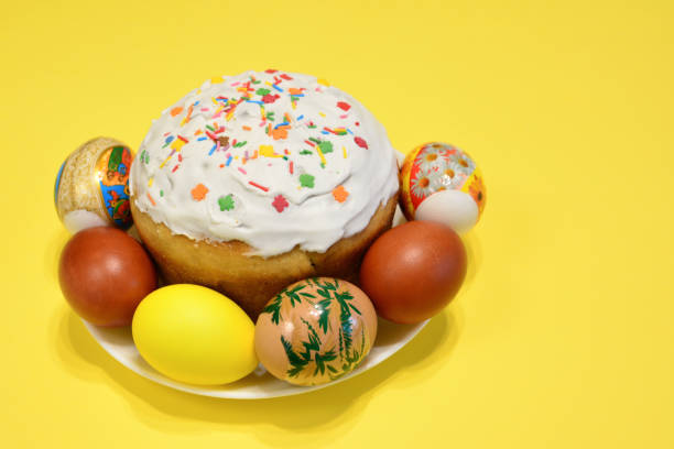 A plate of colorful eggs and a cake with sugar sprinkles isolated copy space