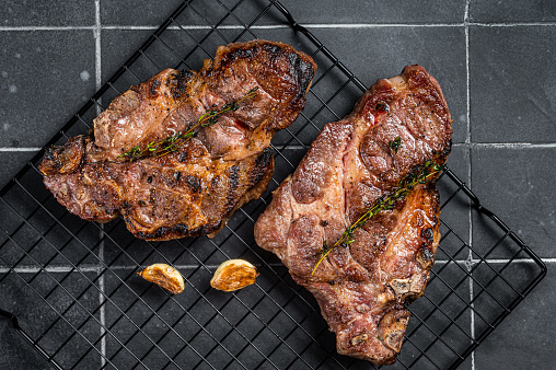 BBQ Grilled Pork loin steaks, neck meat. Black background. Top view.