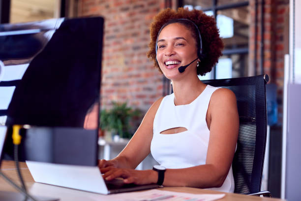 istock Businesswoman Wearing Headset At Computer In Customer Support Centre 1470930702